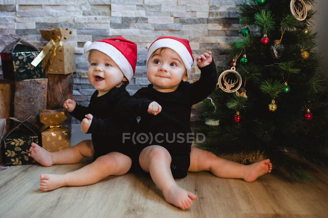Glückliche Babys neben Weihnachtsbaum und Geschenken — Stockfoto
