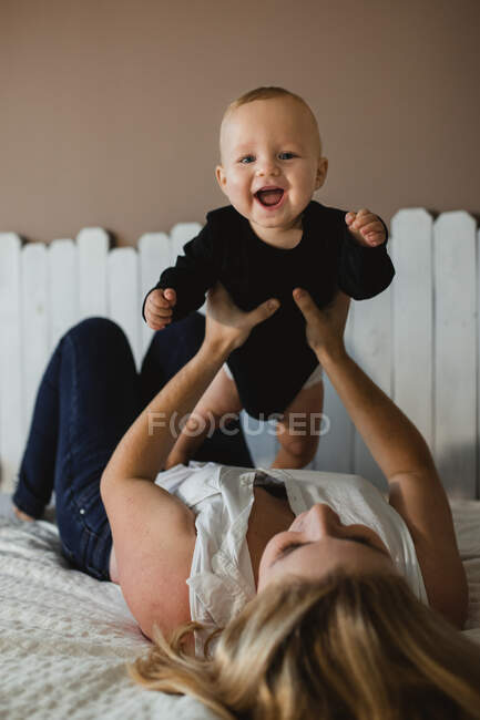 Mutter spielt mit Baby im Bett — Stockfoto