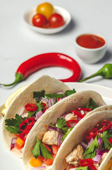 Мексиканські тако з свіжими овочами та куркою на білому тлі. — стокове фото