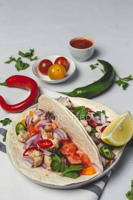 Tacos mexicanos caseros con verduras frescas y pollo sobre fondo blanco - foto de stock