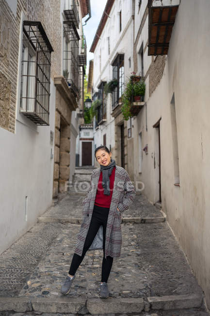 Joyful female tourist in casual wear amid city street — Stock Photo