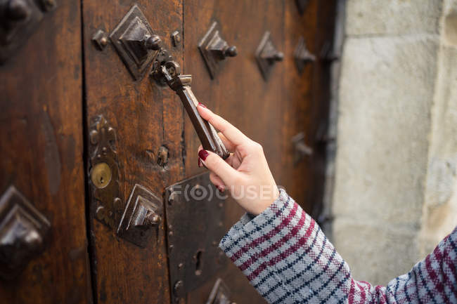 Hand einer Reisenden in Freizeitkleidung klappert in uralter Tür an der Stadtstraße — Stockfoto