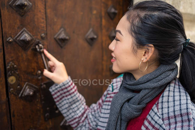 Curioso viaggiatore femminile in abbigliamento casual che si scontra in antica porta di strada della città — Foto stock