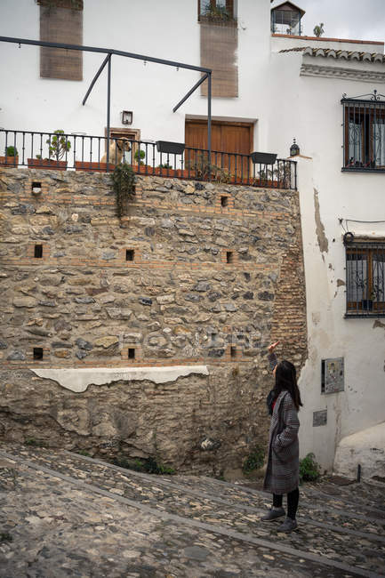 Donna camminando su vecchi gradini di ciottoli nel vicolo della città — Foto stock