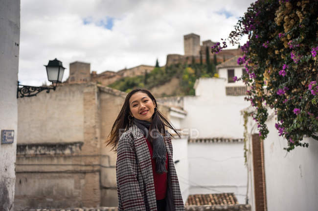Ásia mulher viajante no Quente desgaste sorrindo entre idade edifícios perto Grande castelo — Fotografia de Stock