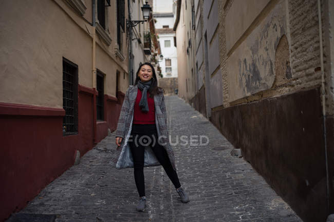 Joyful Asian resting female hiking on old rocked narrow street. - foto de stock