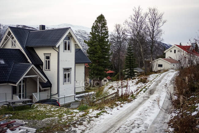Vista incrível wintry do campo com casas coloridas contra colinas nevadas — Fotografia de Stock