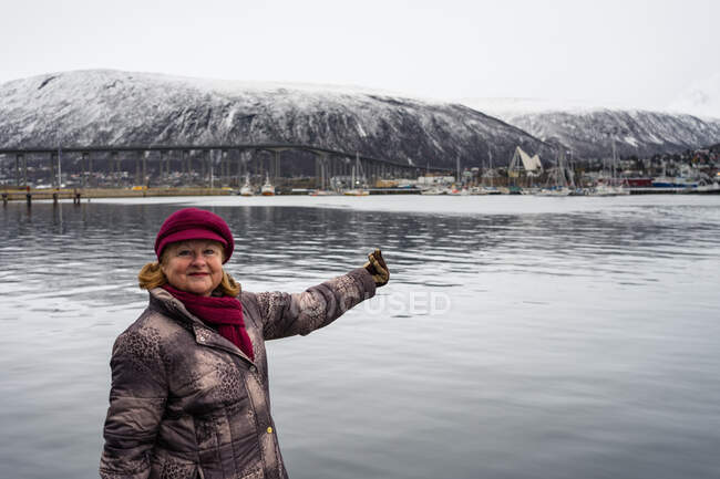 Senior resting female in warm wear pointing on beautiful landscape — Stock Photo