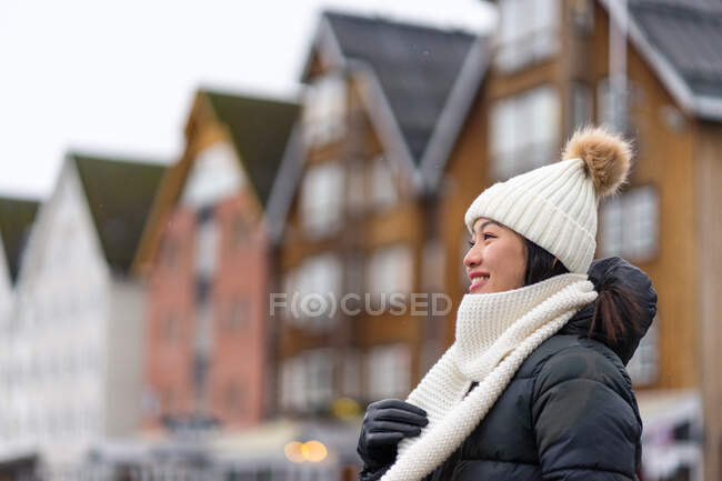 Asiatische ruhende junge Dame in warmer Kleidung spaziert auf der Stadtstraße — Stockfoto