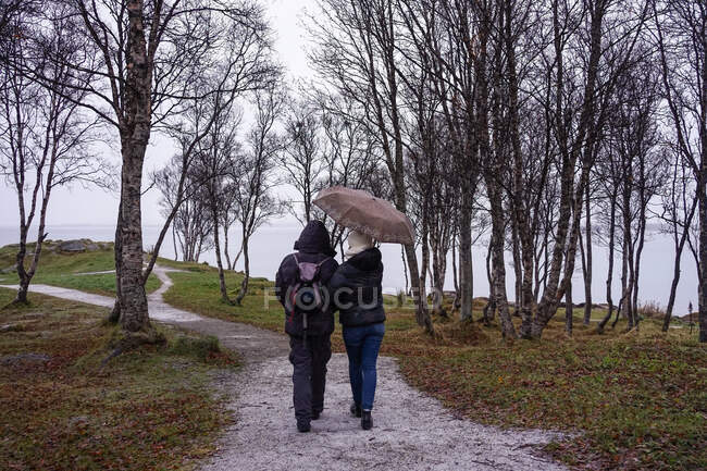 Amigos caminhando no caminho do parque perto do mar — Fotografia de Stock