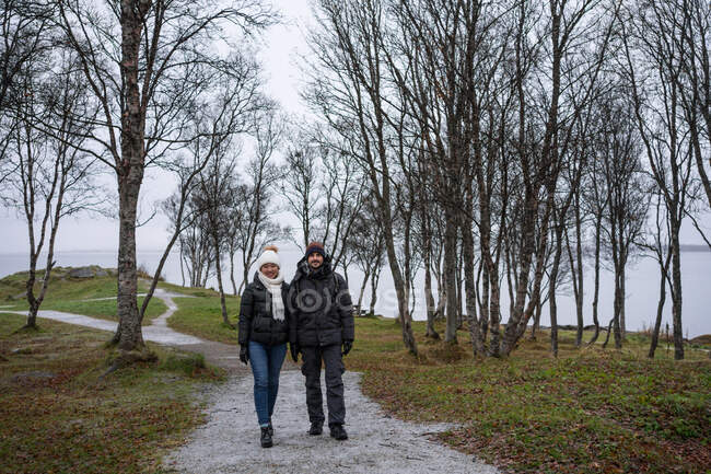 Couple walking on park path near sea — Stock Photo