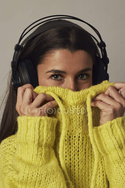 Playful young woman listening to music in studio — Stock Photo