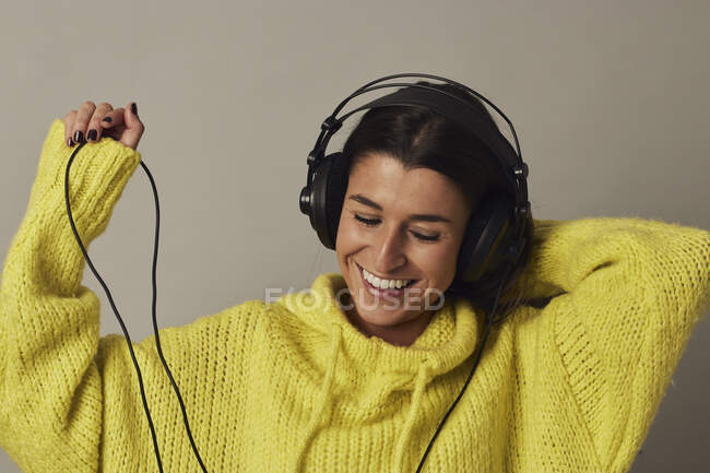 Играющая молодая женщина слушает музыку в студии — стоковое фото