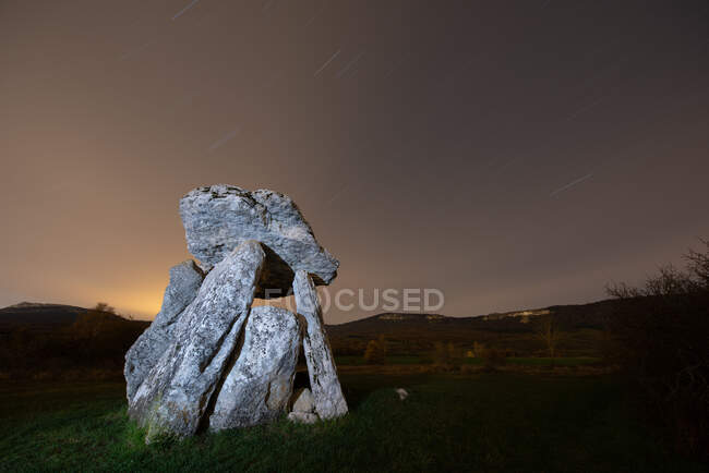 Dolmen antiguo contra el cielo nocturno - foto de stock