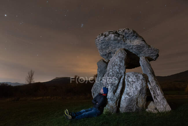 Viajante admirando céu estrelado perto de dolmen — Fotografia de Stock