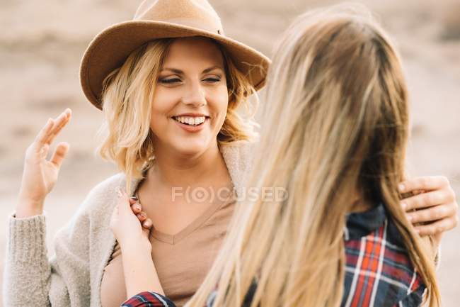 Две красивые блондинки обнимаются, как отдыхающие в пустыне днем — стоковое фото