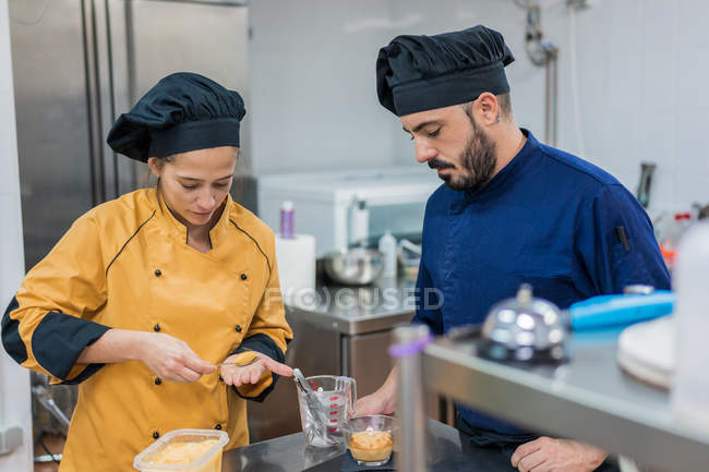 Koch mit Kollege serviert Essen auf Teller — Stockfoto