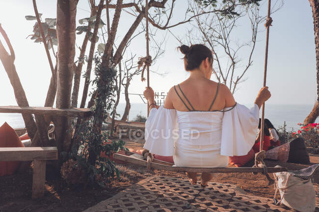 Young woman sitting on swing — Stock Photo