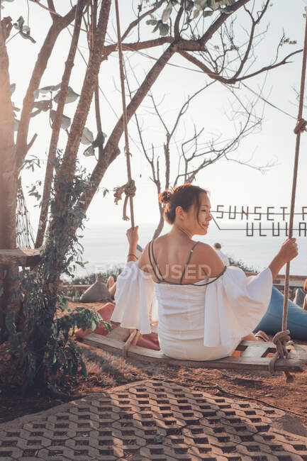Jeune femme assise sur swing — Photo de stock