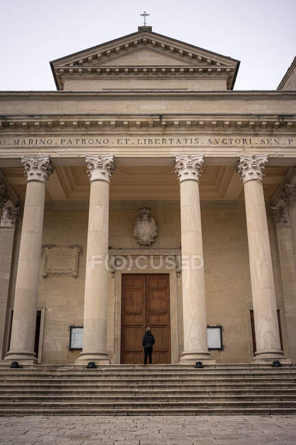 Vista posteriore di persona in piedi sulle scale e guardando grande antico grande edificio — Foto stock