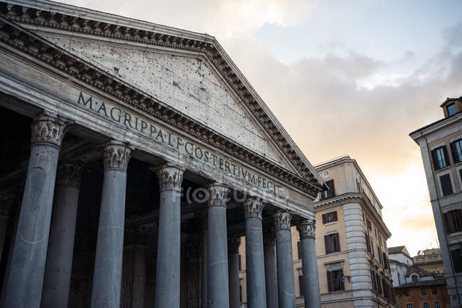 Снизу снаружи старинного здания Пантеона, расположенного на улице Рима против облачного закатного неба в Италии — стоковое фото