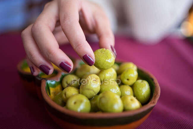 Mulher asiática comendo azeitonas no restaurante — Fotografia de Stock