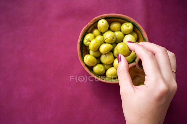 Азиатка ест оливки в ресторане — стоковое фото