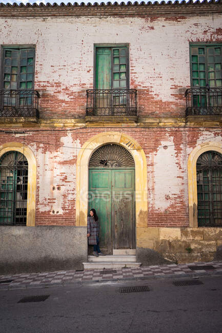 Женщина на улице со старым зданием — стоковое фото