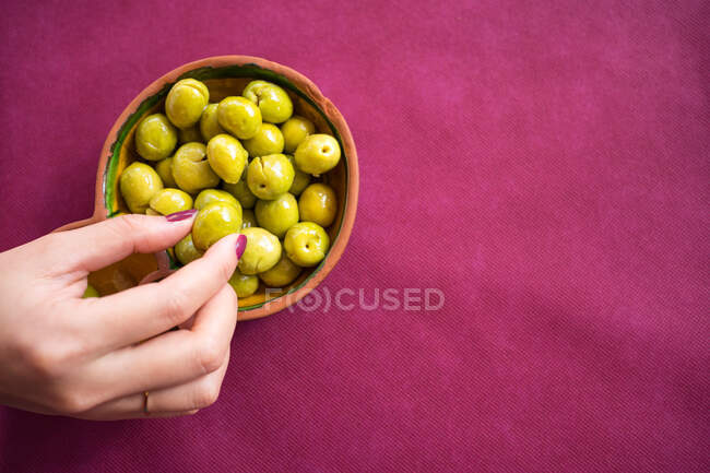 Asian woman eating olives in restaurant — Stock Photo