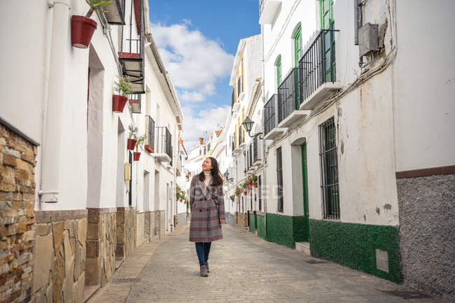 Счастливая женщина прогуливается по пустой узкой улице — стоковое фото