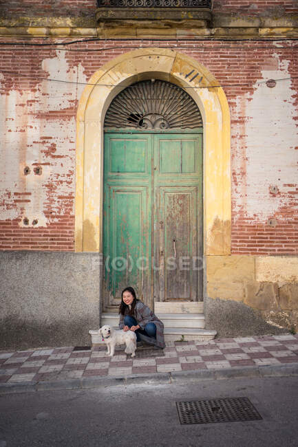Señora pacífica acariciando perro en la calle - foto de stock