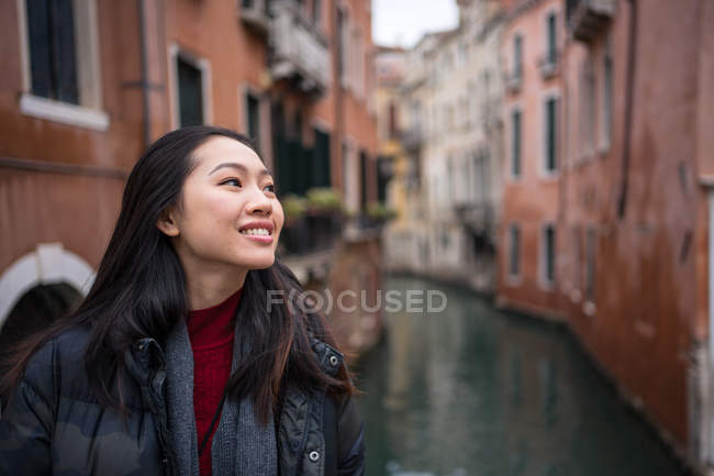 Soddisfatto asiatico riposo donna esplorare vecchio città con corsi d'acqua — Foto stock