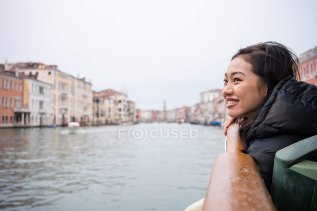 Mujer asiática de vacaciones ob ferryboat en la línea de flotación en la ciudad - foto de stock