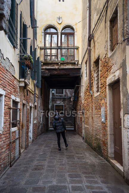 Back view of woman strolling on rocked alley — Stock Photo