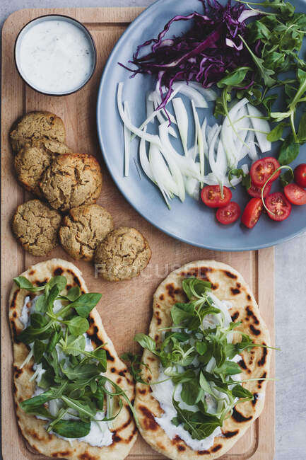 Kochtisch mit Falafel und frischem Gemüse auf Brot.near mit Salat — Stockfoto