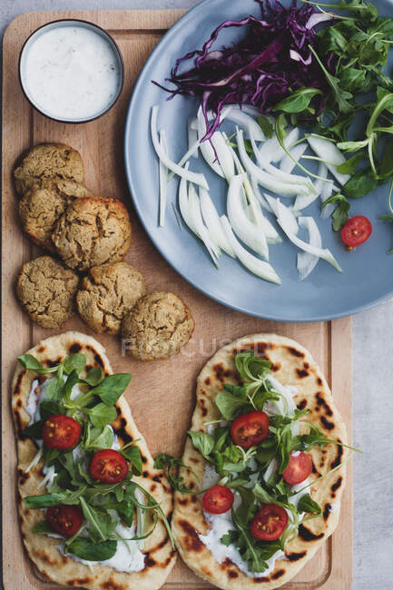 Cooking table with falafel and fresh vegetables on bread.near with salad — Stock Photo