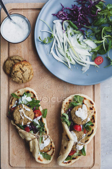Tavolo da cucina con falafel e verdure fresche sul pane.near con insalata — Foto stock