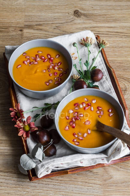 From above arrangement with creamy pumpkin soup with chestnut and pomegranate seeds in bowl with spoon — Stock Photo