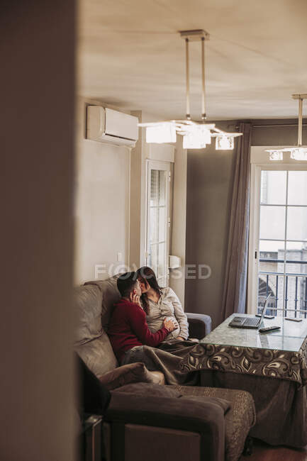 Couple expecting baby kissing at home — Stock Photo