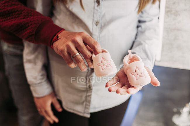 Casal esperando bebê segurando botas de bebê — Fotografia de Stock
