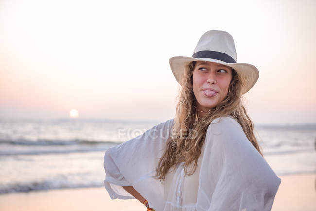 Charmante Frau in hellweißem Kleid am welligen Strand — Stockfoto