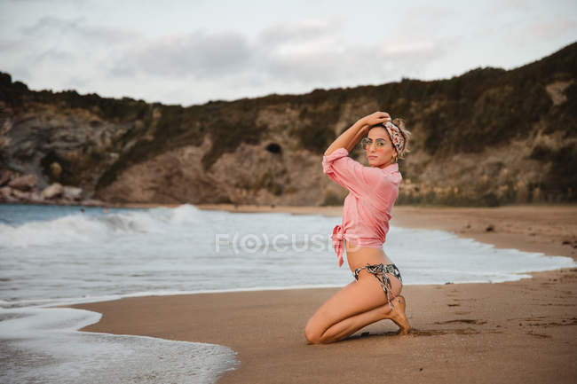 Stylish woman resting on seashore — Stock Photo