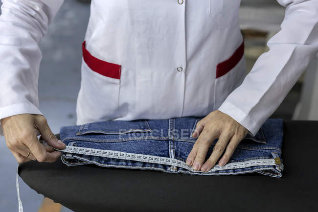 Cropped image of worker in textile factory ironing on industrial sewing machine. Industrial production — Stock Photo