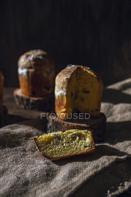 Traditional panettones with raisins on rustic cloth — Stock Photo