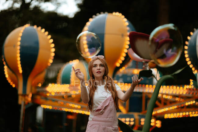 Підліткова жінка грає з мильними бульбашками в парку розваг — стокове фото