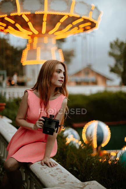 Millennial woman taking picture with camera in amusement park — Stock Photo