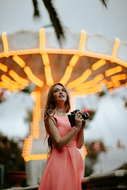 Millennial donna scattare foto con macchina fotografica nel parco divertimenti — Foto stock