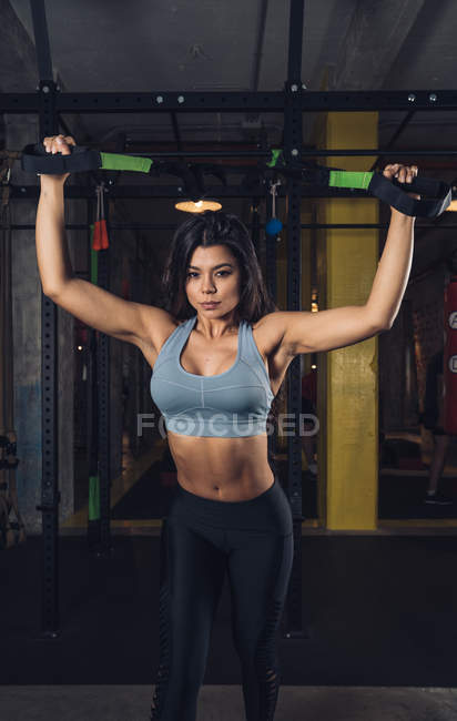 Femme tirant des cordes et s'entraînant dans la salle de gym — Photo de stock