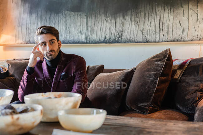 Ruhiger eleganter Mann auf Sofa im Wohnzimmer — Stockfoto