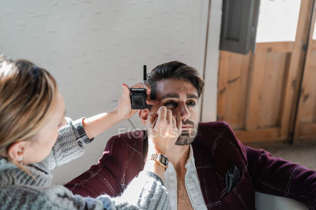 Maquiagem artista aplicando maquiagem no modelo masculino — Fotografia de Stock
